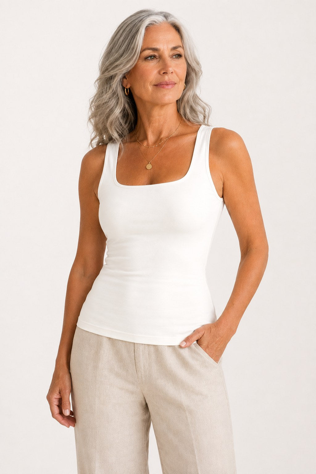 Woman wearing the Faye Built-In Support Tank in Ivory with linen trousers