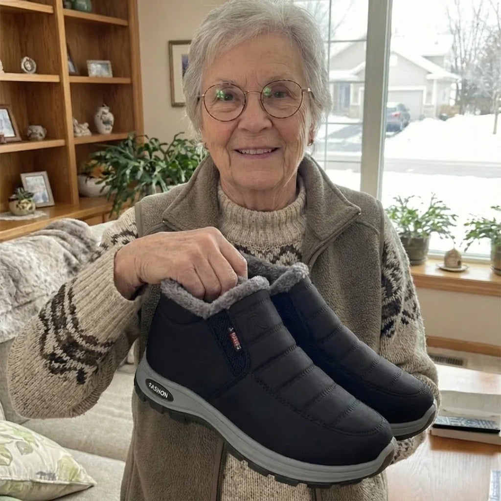 Woman holding a pair of Sianna boots in black